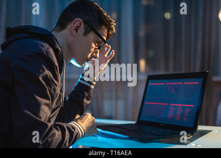 Cybercriminal hacker typing program code while stealing access databases with passwords. The concept of cyber security Stock Photo