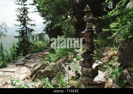 Equilibrium form small rocks - pile on mountain road standing firmly. Harmony in nature made by human. Stock Photo