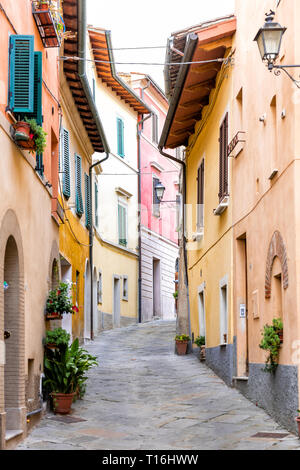 Chiusi, Italy street narrow alley in small historic town village in Umbria vertical view during sunny day with orange yellow bright vibrant colorful w Stock Photo