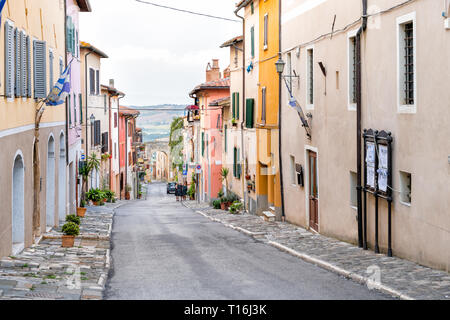 Chiusi, Italy - August 25, 2018: Empty street in small town village in Umbria Tuscany narrow road view during day with orange yellow bright vibrant vi Stock Photo