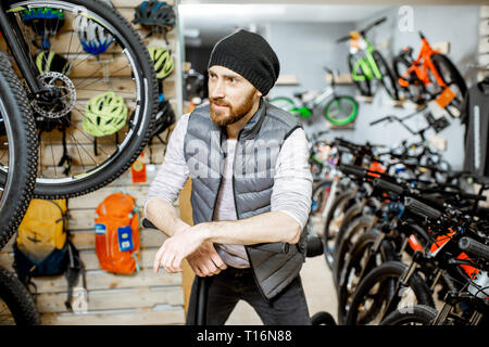 Portrait of a stylish man with folding bicycle at the bicycle shop Stock Photo