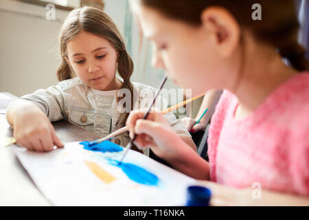 Two Sisters Painting Together Stock Photo