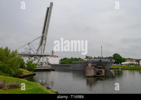 The Cindia, a general cargo ship, passing under the new Caen Canal/Pegasus Bridge, a rolling lift bridge, Normandy, France. Stock Photo