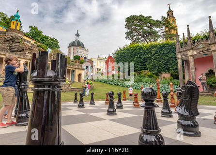 Kids playing with giant chess pieces in the village center, Portmeirion, Gwynedd, North Wales, United Kingdom Stock Photo