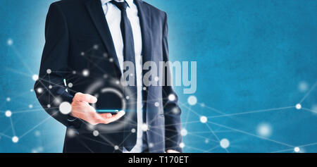 businessman using smartphone for business networking, man holding mobile phone with network graphic illustration and blue background copy space Stock Photo