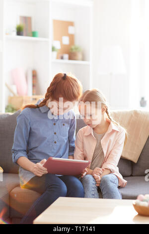 Two Sisters Using Tablet Stock Photo