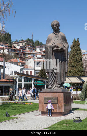 A young boy is posing in front of Statue of  St. Naum Ohridski, monument at Ohrid, Macedonia Stock Photo