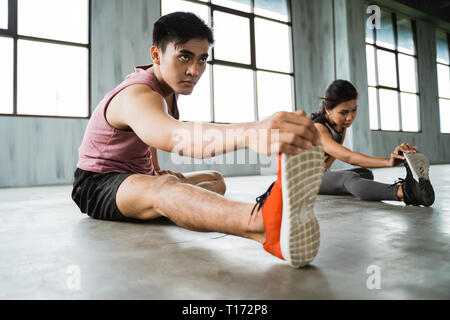 asian young man doing legs stretching before core exercise Stock Photo