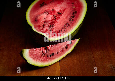 Fresh sliced and half of watermelon on wooden table Stock Photo