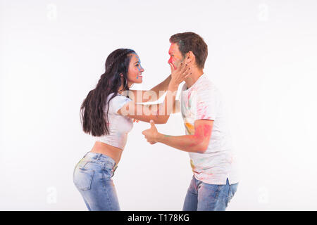 Festival of holi, social dance, friendship - young people playing with colors at the festival of holi and dancing bachata or kizomba on white Stock Photo