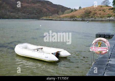 Dinghy inflatable boat at pontoon jetty in Crinan harbour Scotland Stock Photo