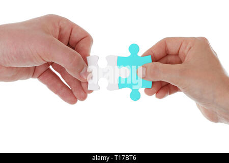 Hands holding and joining two pieces of puzzle together isolated on white.Teamwork partnership cooperation and matching concept Stock Photo