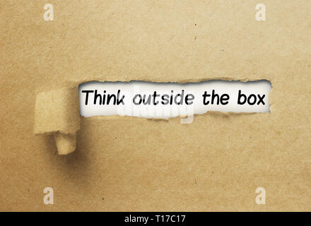 Think outside the box behind ripped curl paper Stock Photo