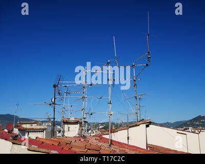 Television aerials against a blue sky on terracotta roofs in Florence, Italy Stock Photo