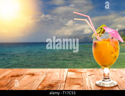 Summer fruit drinks or juice with ocean beach on background Stock Photo