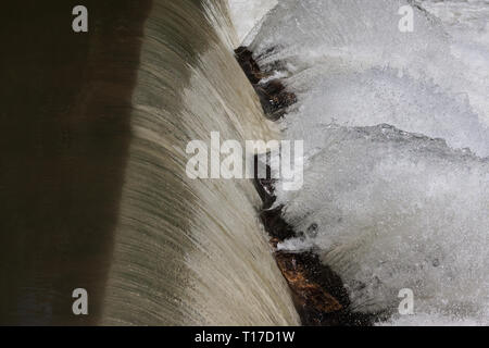 The motion of water violently splashing off rocks is frozen at a waterfall along the Chattahoochee River in north Georgia. Stock Photo