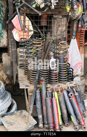 Variety of used refurbished and partly painted auto and motorbike springs and shock absorber for sale at a poor market stall in the Philippines Stock Photo