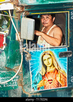 Ibajay, Aklan, Philippines: Driver of an old Jeepney, decorated with a painting of Mother Mary, joining the Ati-Atihan Festival Stock Photo