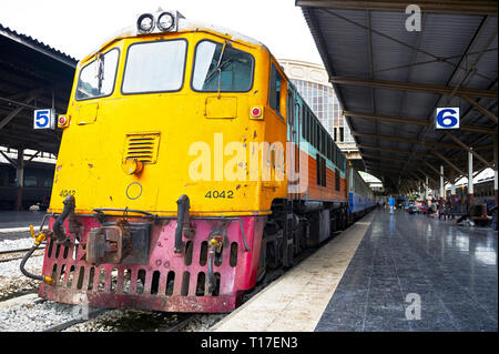 Hualamphong Central Train Station in Bangkok, Thailand - June 14 2011: Low-angle view of a massive yellow train waiting at a platform for passengers Stock Photo