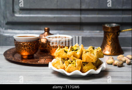 Arabic baklava dessert with coffee in copper cups Stock Photo