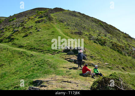 Walkers having a rest on a hilly route along the coast, having walked up from Heddon Valley, Devon, UK