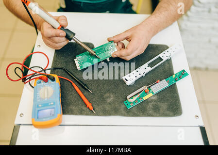 Repairman fixing problem with refrigerator at home Stock Photo