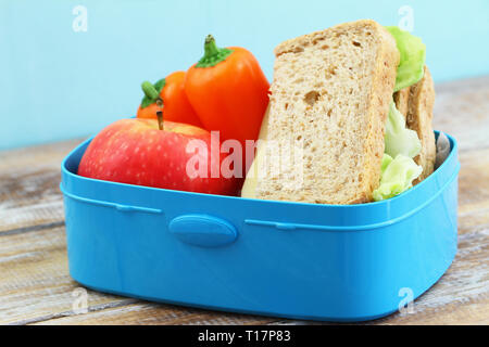 Healthy school lunchbox  containing brown cheese sandwich, crunchy yellow pepper and apple Stock Photo