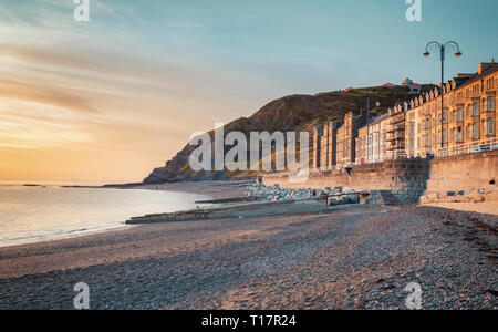 Scenic coastal town in warm sunset light at low tide. Aberystwyth in Wales, UK Stock Photo