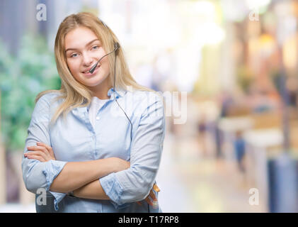 Young caucasian business woman wearing call center headset over isolated background happy face smiling with crossed arms looking at the camera. Positi Stock Photo