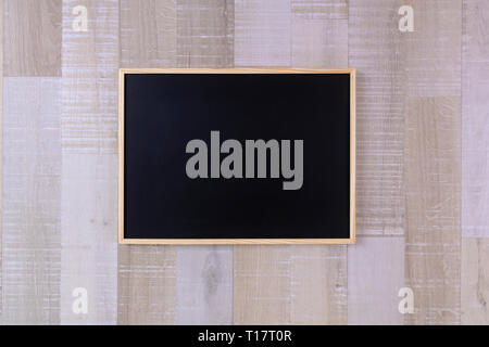 Front view of a blank blackboard over a weathered wooden surface Stock Photo