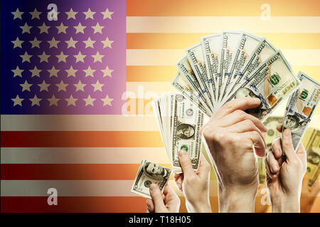 People raising hands dollars and American flag on background. Patriotic concept Stock Photo