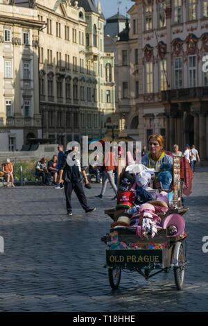 Prague, Czech Republic - September 10, 2019: Street vendor woman with a souvernirs car sells remenbrances in the old city plaza Stock Photo