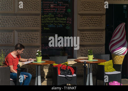 Krakow, Poland - September 21, 2019: Tourist reads the menu in a bar near Wawel castle Stock Photo