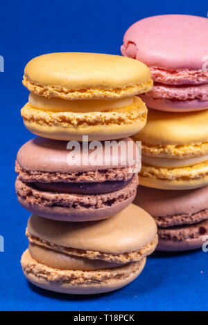 Colorful french macarons isolated on blue background. Pastel colors - Imagen Stock Photo