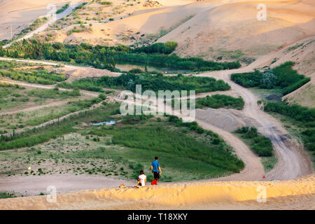 A young family enjoying the view of Kubuqi desert, in the Ordor highland of Inner Mongolia, China. Stock Photo