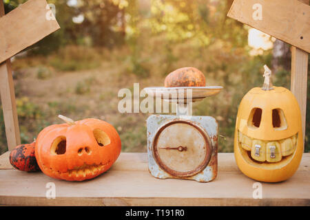 Ghost pumpkins on Halloween. ead Jack on an autumn background. Holiday outdoor decorations Stock Photo