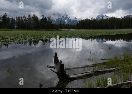 Dark Clouds Brood Over Waters of Heron Pond with Tetons  in Background Stock Photo