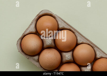 Raw hen eggs in a carton with a colourful background. Stock Photo