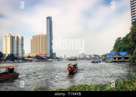 This unique photo shows like the old traditional long tail boats driving on the Mae Nam Chao Phraya River in Bangkok Stock Photo