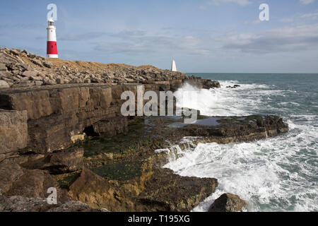 Waves crashing on to rocky shore near the lighthouse at Portland Bill Dorset England Stock Photo
