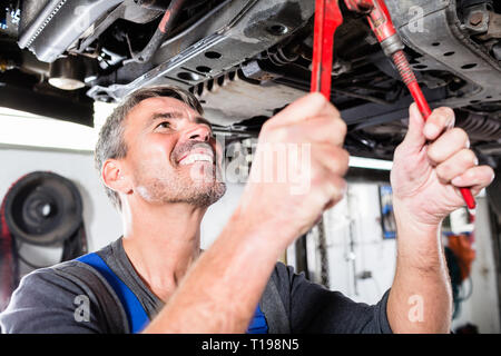Smiling mature man repairing the car Stock Photo