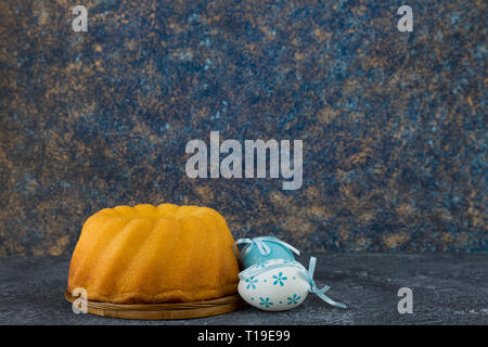 Easter bread and blue Easter eggs on dark stone table Stock Photo