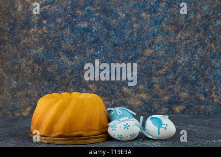 Easter bread and blue Easter eggs on dark stone table Stock Photo