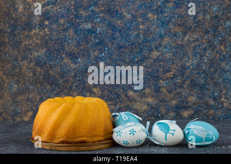 Easter bread and blue Easter eggs on dark stone table Stock Photo