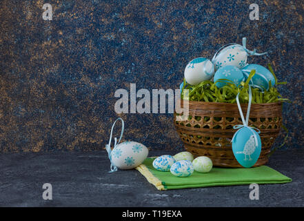 Easter basket with coloured Easter eggs on dark stone table Stock Photo