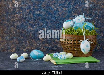 Easter basket with coloured Easter eggs on dark stone table Stock Photo