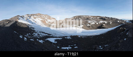 Panoramic view across the crater at the top of Kilimanjaro taken from close to Stella Point. A path leads up to Uhuru Peak just left of the centre. Stock Photo