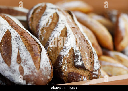 Artisanal bread on the wooden shelf in the bakery shop. Selective focus.