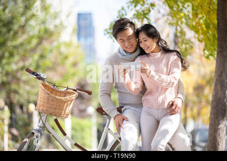 Happy young couple using smartphone Stock Photo