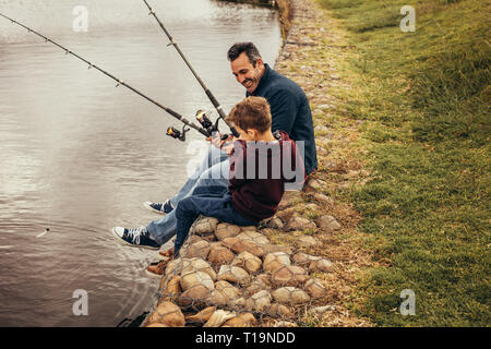 Child with fishing rod on wooden pier Stock Photo by ©Tverdohlib